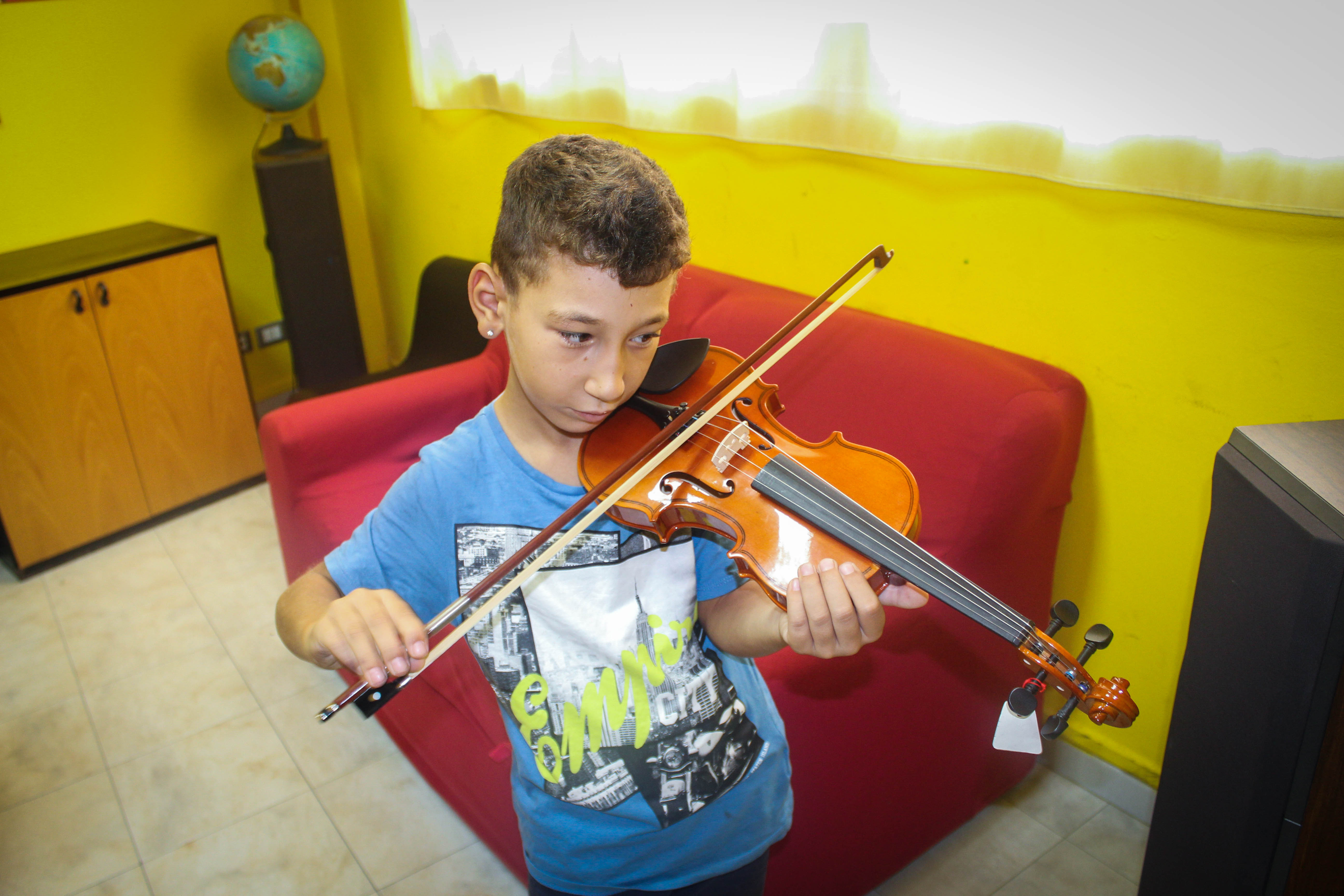 Un bambino della comunità educante sperimenta il suo violino