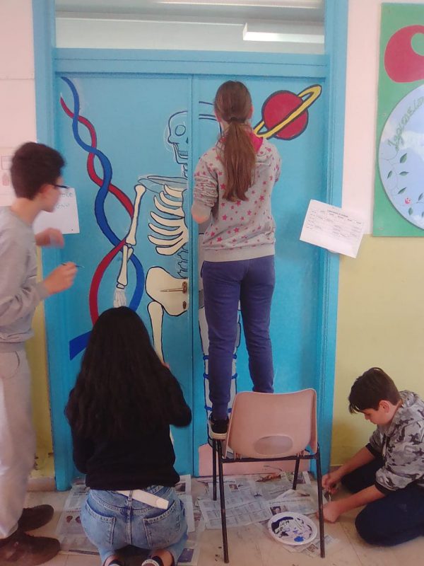 Alla scuola Armando Sforzi di Piano di Conca, i ragazzi dipingono la porta del laboratorio di scienze grazie ai Pomeriggi di Archimede, del progetto Manchi solo tu